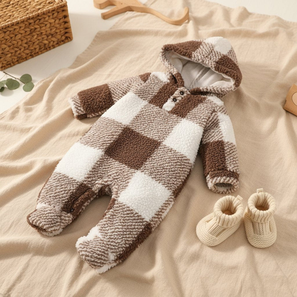 Combinaison Bébé Peluche 3-24 Mois, coloris carreaux marron, posée à plat sur un lit en lin