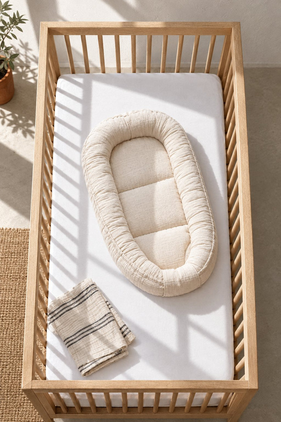 Réducteur de lit bébé installé dans un lit à barreaux