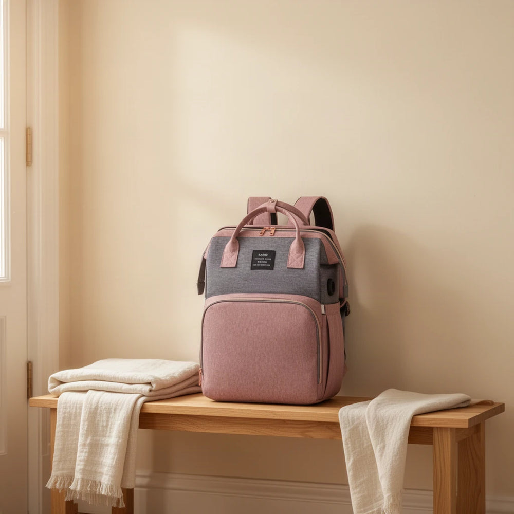 Sac à dos à langer 3 en 1 avec couchette et port USB posé sur un banc dans une entrée