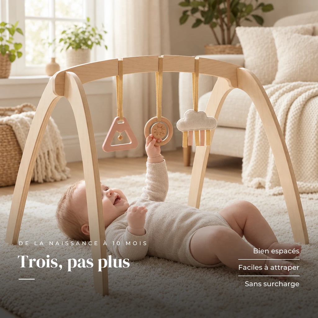 Bébé allongé sur le dos qui attrape un jouet suspendu : Arche d'éveil en bois - Triple Jouets