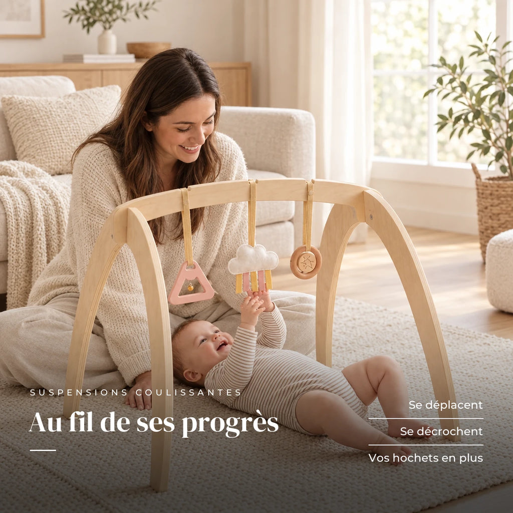 Un parent regarde son bébé jouer : Arche d'éveil en bois - Triple Jouets