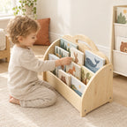 Enfant de 3 ans qui choisit seul un livre dans la bibliothèque enfant 3-en-1 en bois