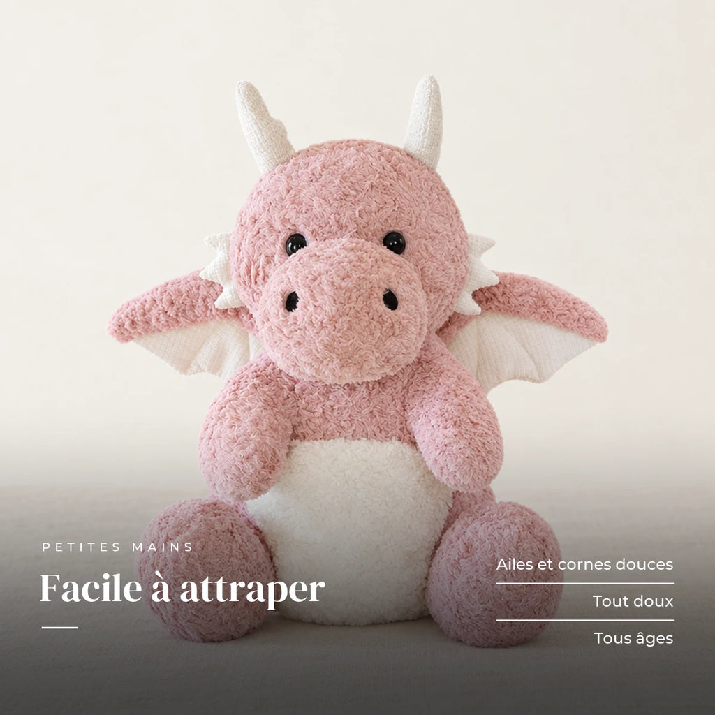 Dragon moelleux en peluche 30 cm rose sur fond crème, en studio. Facile à attraper : ailes et cornes douces, tout doux, tous âges