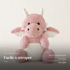 Dragon moelleux en peluche 30 cm rose sur fond crème, en studio. Facile à attraper : ailes et cornes douces, tout doux, tous âges