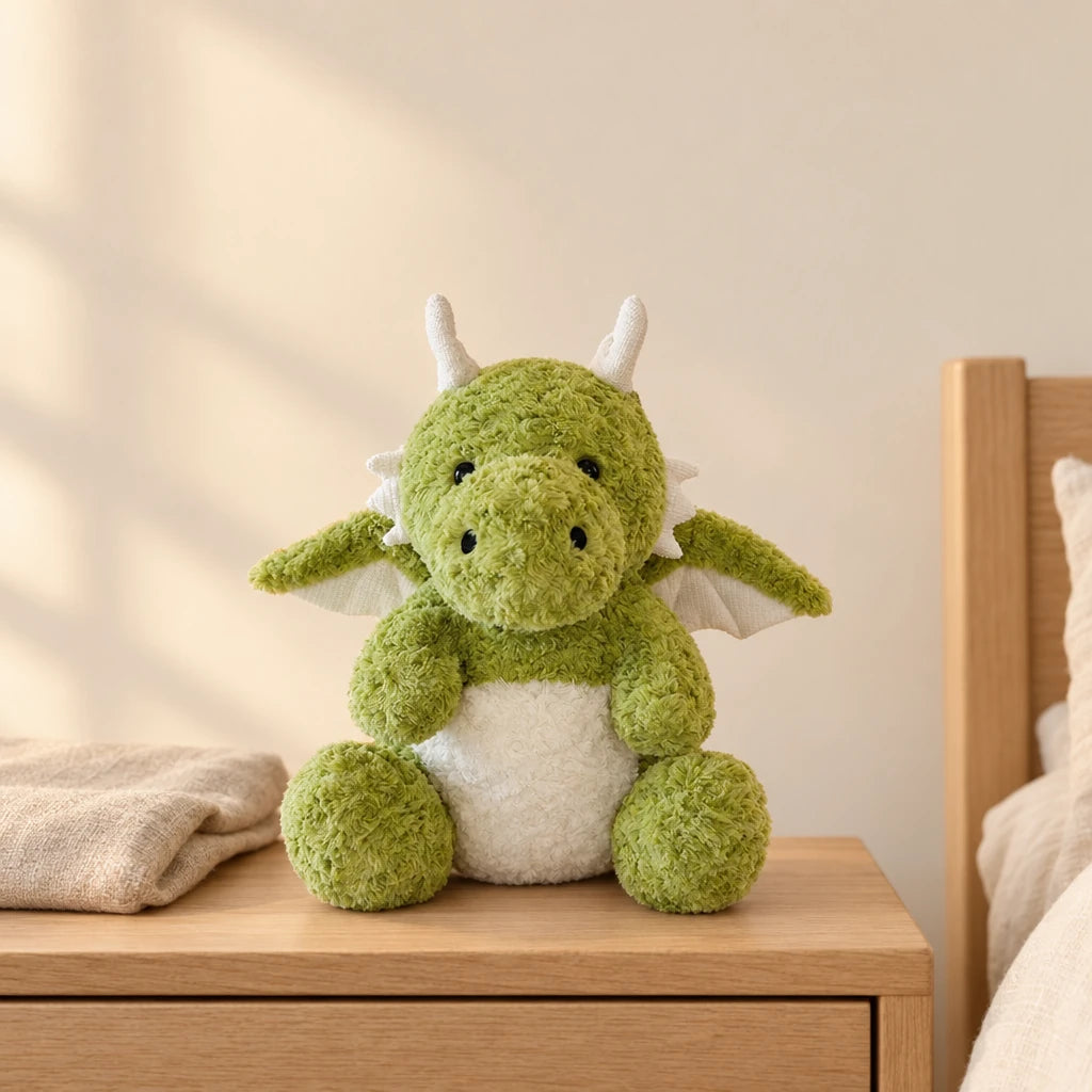 Dragon moelleux en peluche 30 cm vert posé sur une table de chevet en bois clair