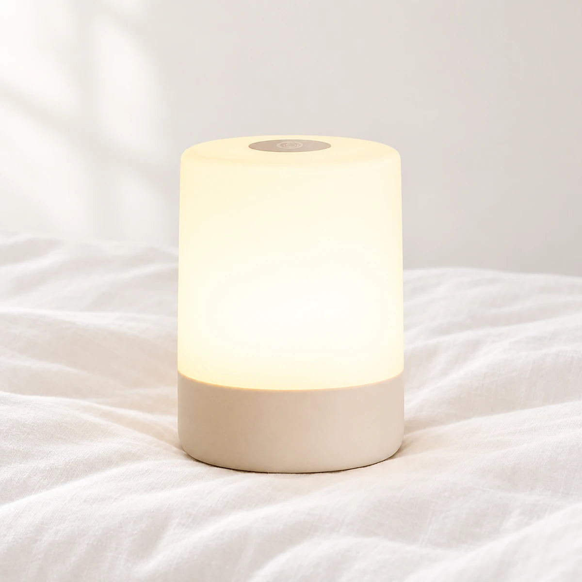 Veilleuse tactile LED rechargeable en gros plan sur un drap blanc