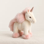 Licorne en peluche debout à crinière colorée rose sur fond crème, en studio
