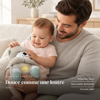 Peluche loutre qui respire dans les bras d’un bébé éveillé. Douce comme une loutre : polyester doux, sans petits éléments, format câlin