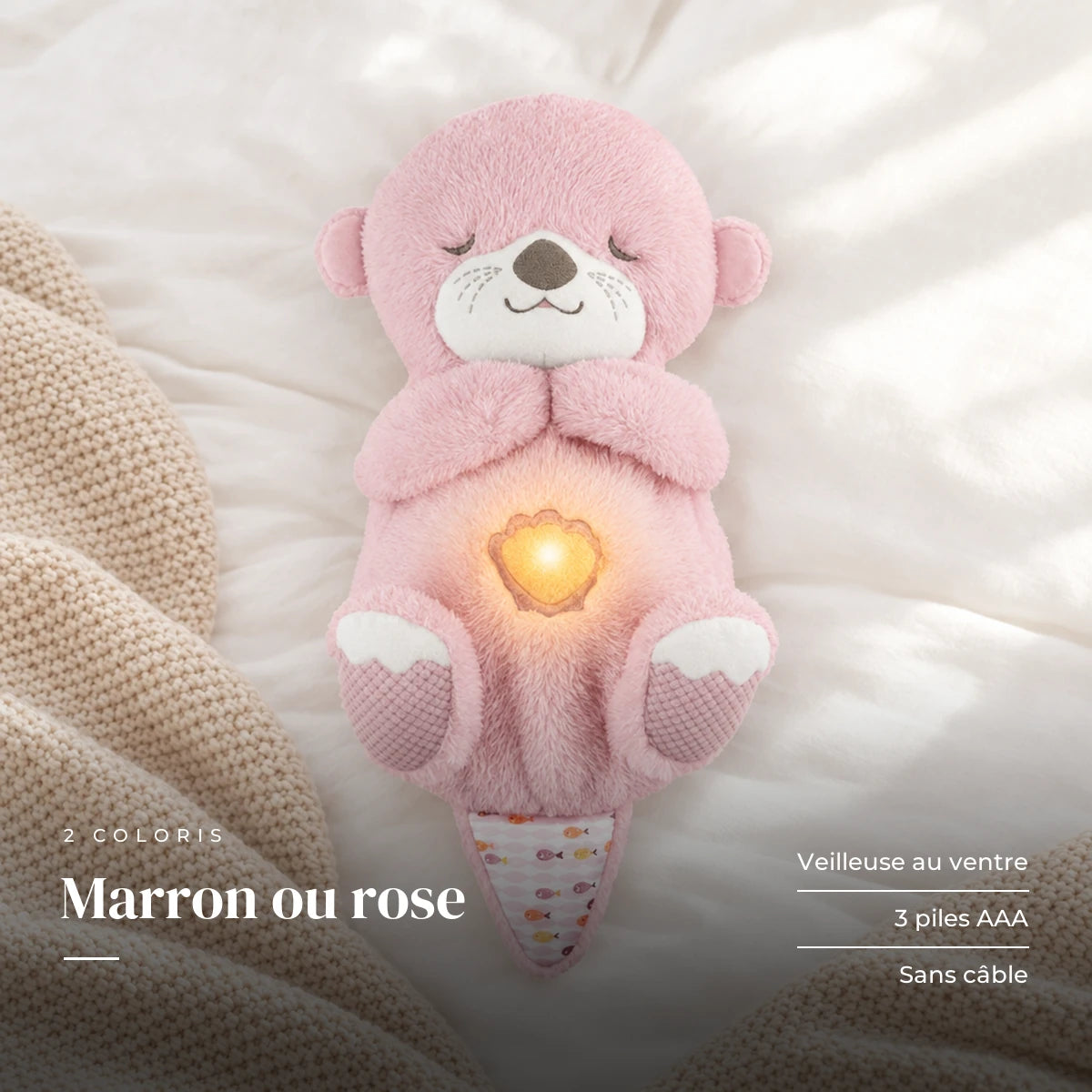 Peluche loutre qui respire rose sur fond crème, en studio. Marron ou rose : veilleuse au ventre, 3 piles AAA, sans câble