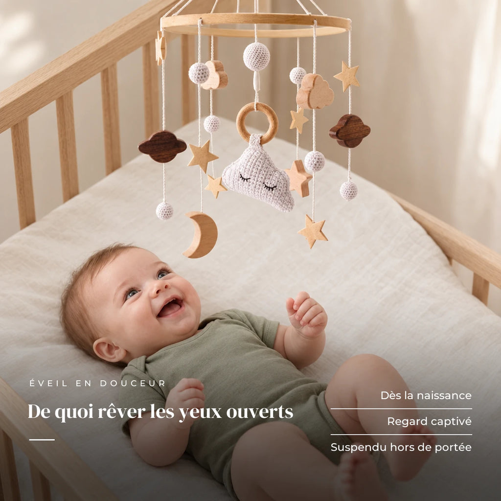 Bébé allongé dans son lit qui regarde le mobile bébé Cododo en bois au-dessus de lui. De quoi rêver les yeux ouverts : dès la naissance, regard captivé, suspendu hors de portée