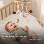 Bébé allongé dans son lit qui regarde le mobile bébé Cododo en bois au-dessus de lui. De quoi rêver les yeux ouverts : dès la naissance, regard captivé, suspendu hors de portée