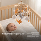 Bébé allongé dans son lit qui regarde le mobile bébé Corail en bois au-dessus de lui. Son premier spectacle : dès la naissance, regard captivé, suspendu hors de portée