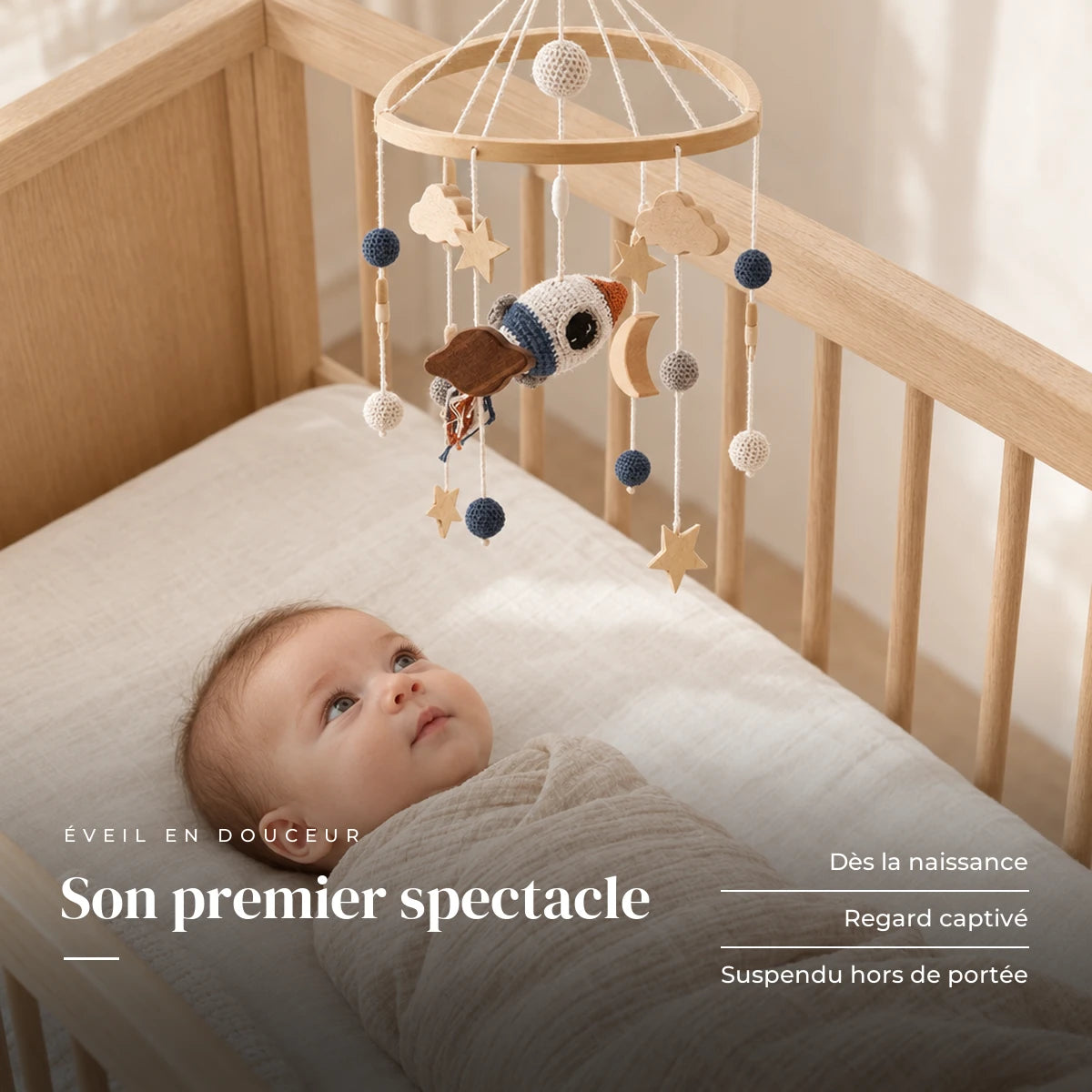Bébé allongé dans son lit qui regarde le mobile bébé Espace en bois au-dessus de lui. Son premier spectacle : dès la naissance, regard captivé, suspendu hors de portée