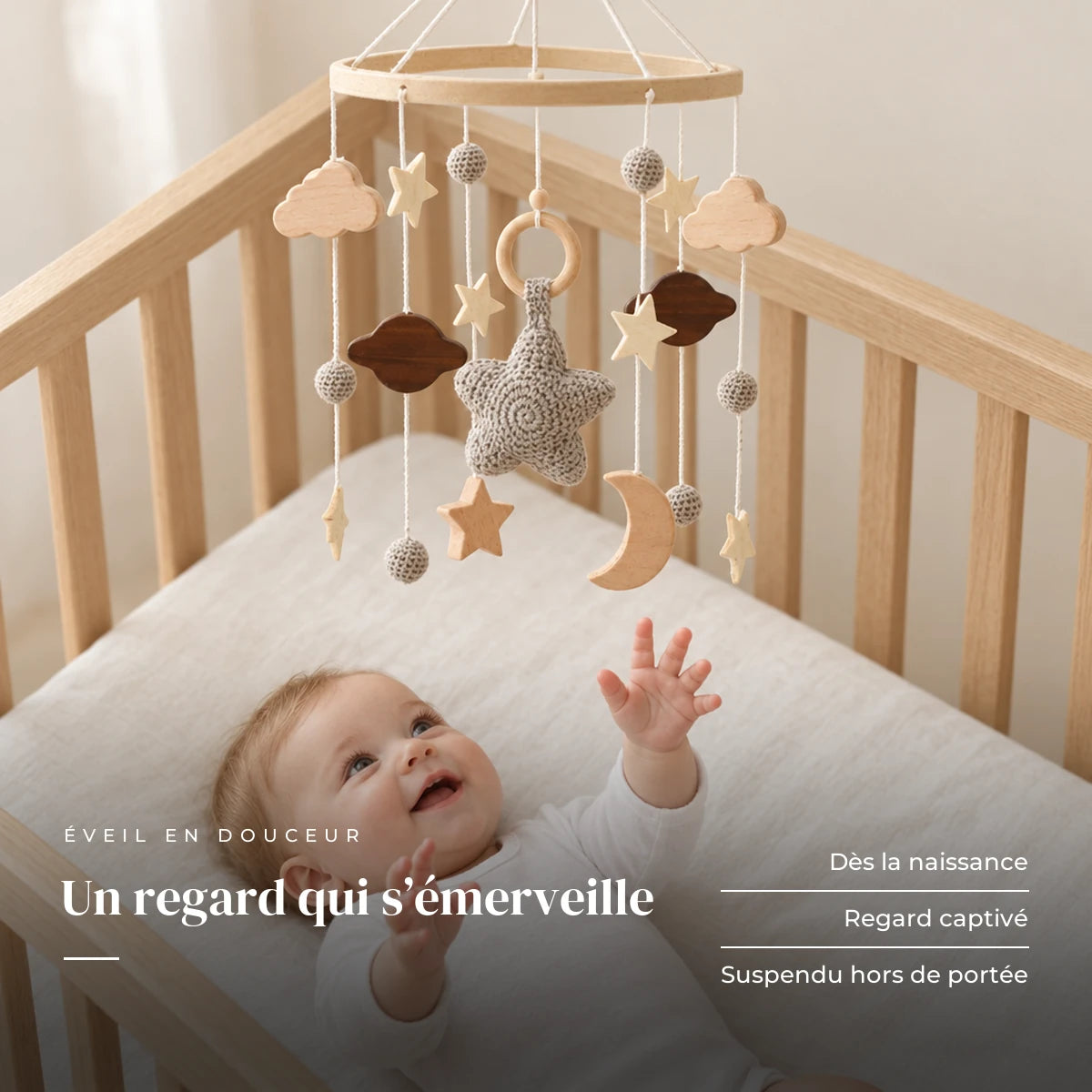 Bébé allongé dans son lit qui regarde le mobile bébé Étoile du berger en bois au-dessus de lui. Un regard qui s’émerveille : dès la naissance, regard captivé, suspendu hors de portée