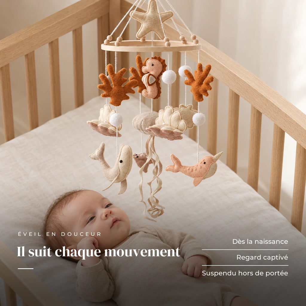 Bébé allongé dans son lit qui regarde le mobile bébé Hippocampe en bois au-dessus de lui. Il suit chaque mouvement : dès la naissance, regard captivé, suspendu hors de portée