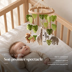 Bébé allongé dans son lit qui regarde le mobile bébé Jungle en bois au-dessus de lui. Son premier spectacle : dès la naissance, regard captivé, suspendu hors de portée
