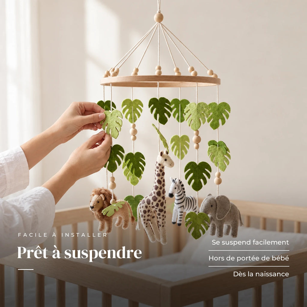 Un parent ajuste une suspension du mobile bébé Jungle en bois au-dessus du lit. Prêt à suspendre : se suspend facilement, hors de portée de bébé, dès la naissance