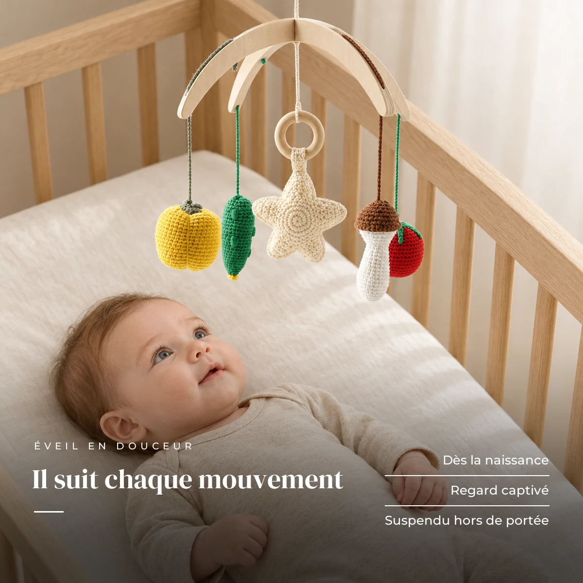 Bébé allongé dans son lit qui regarde le mobile bébé Légumes en bois au-dessus de lui. Il suit chaque mouvement : dès la naissance, regard captivé, suspendu hors de portée