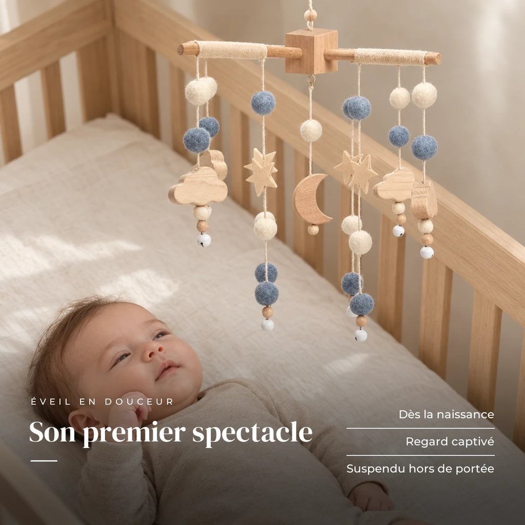 Bébé allongé dans son lit qui regarde le mobile bébé Lune en bois au-dessus de lui. Son premier spectacle : dès la naissance, regard captivé, suspendu hors de portée