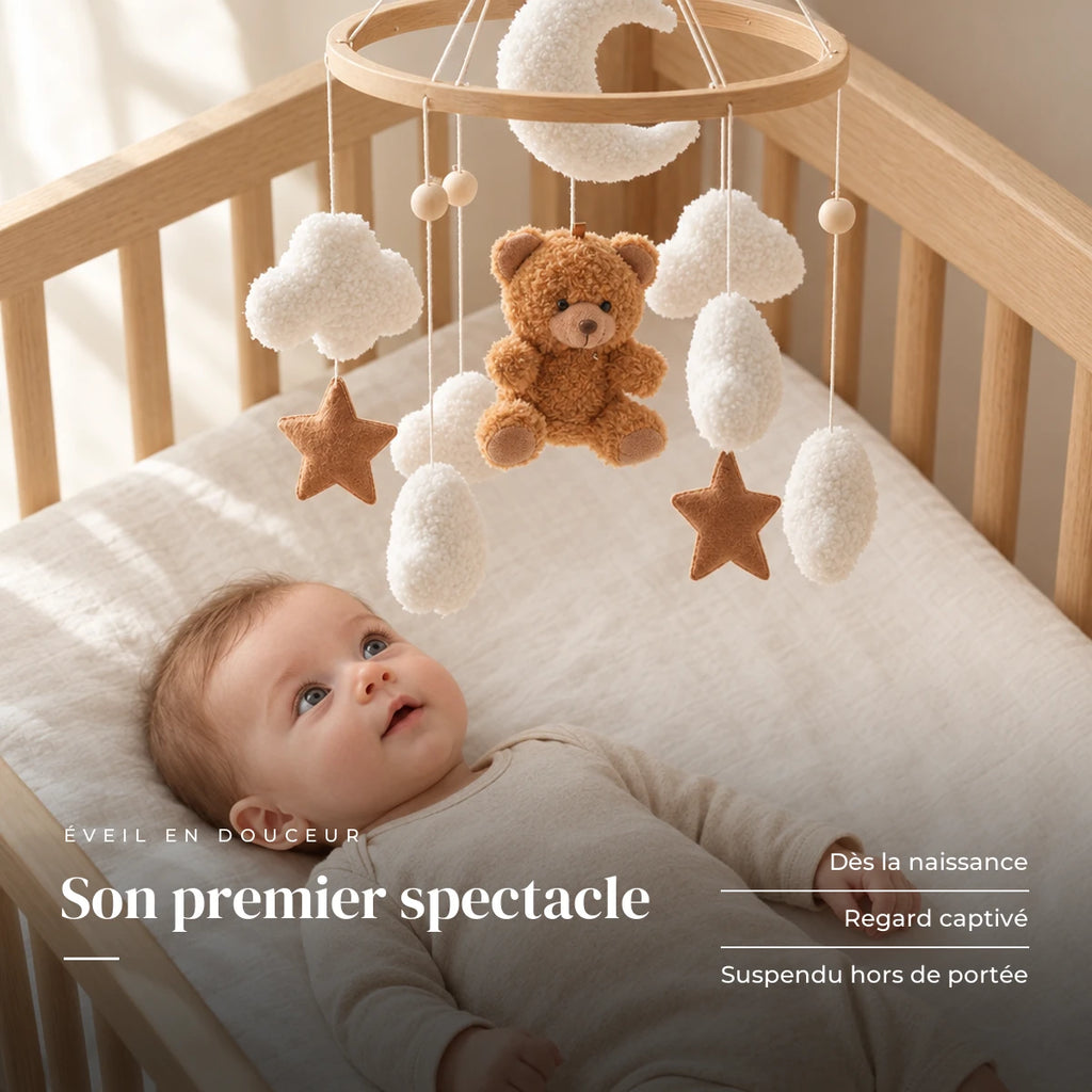 Bébé allongé dans son lit qui regarde le mobile bébé Nounours en bois au-dessus de lui. Son premier spectacle : dès la naissance, regard captivé, suspendu hors de portée