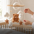 Un parent ajuste une suspension du mobile bébé Nounours en bois au-dessus du lit. Prêt à suspendre : se suspend facilement, hors de portée de bébé, dès la naissance