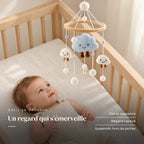 Bébé allongé dans son lit qui regarde le mobile bébé Nuage en bois au-dessus de lui. Un regard qui s’émerveille : dès la naissance, regard captivé, suspendu hors de portée