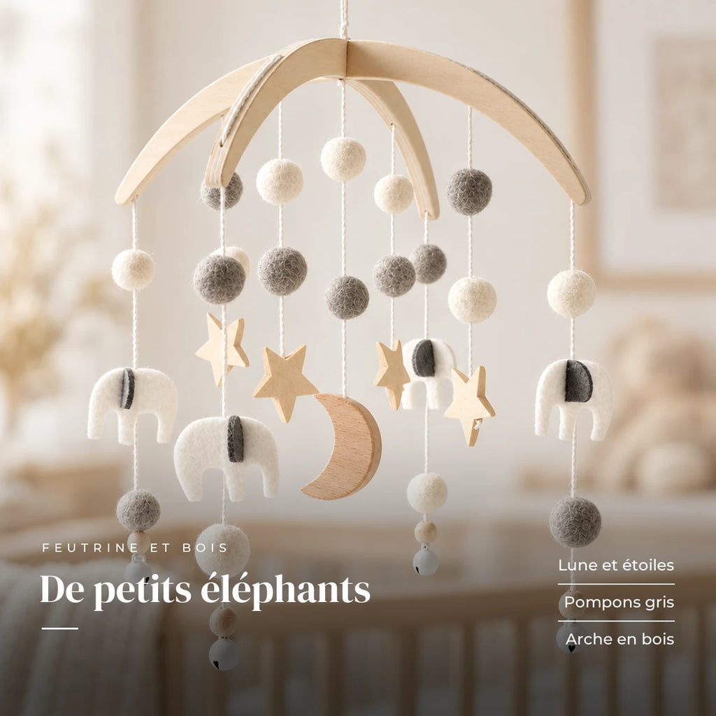Détail des suspensions du mobile bébé Nuit en bois. De petits éléphants : lune et étoiles, pompons gris, arche en bois