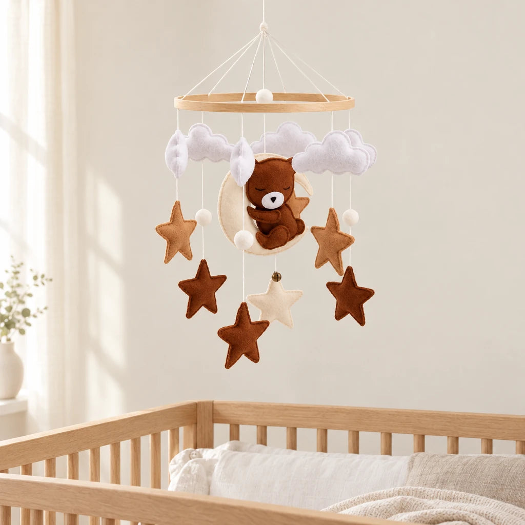 Mobile Bébé Ourson Lune en bois suspendu au-dessus d’un lit bébé en bois clair, dans une chambre douce