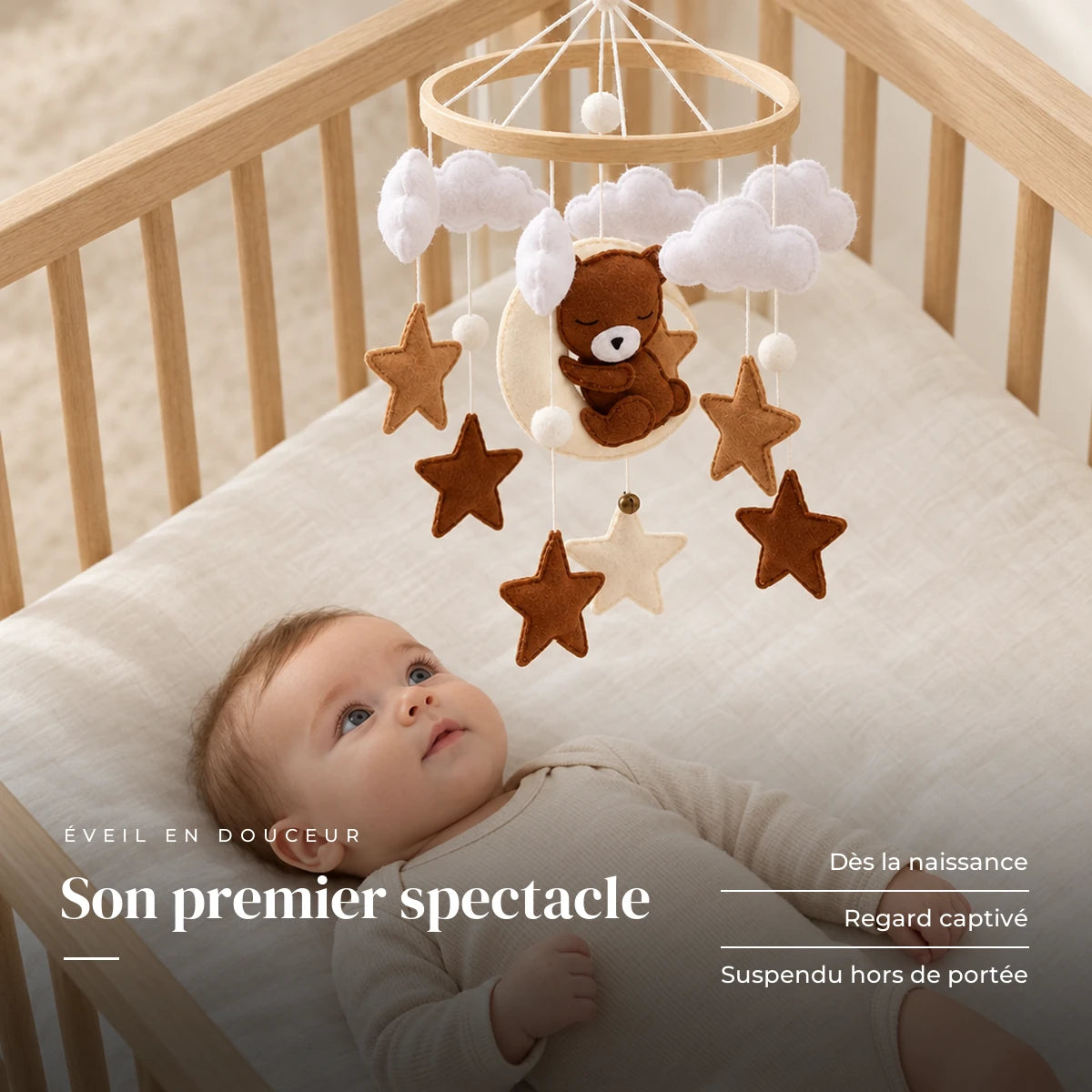 Bébé allongé dans son lit qui regarde le mobile bébé Ourson Lune en bois au-dessus de lui. Son premier spectacle : dès la naissance, regard captivé, suspendu hors de portée