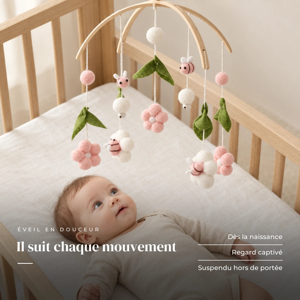 Bébé allongé dans son lit qui regarde le mobile bébé Rose Pour Fille en bois au-dessus de lui. Il suit chaque mouvement : dès la naissance, regard captivé, suspendu hors de portée