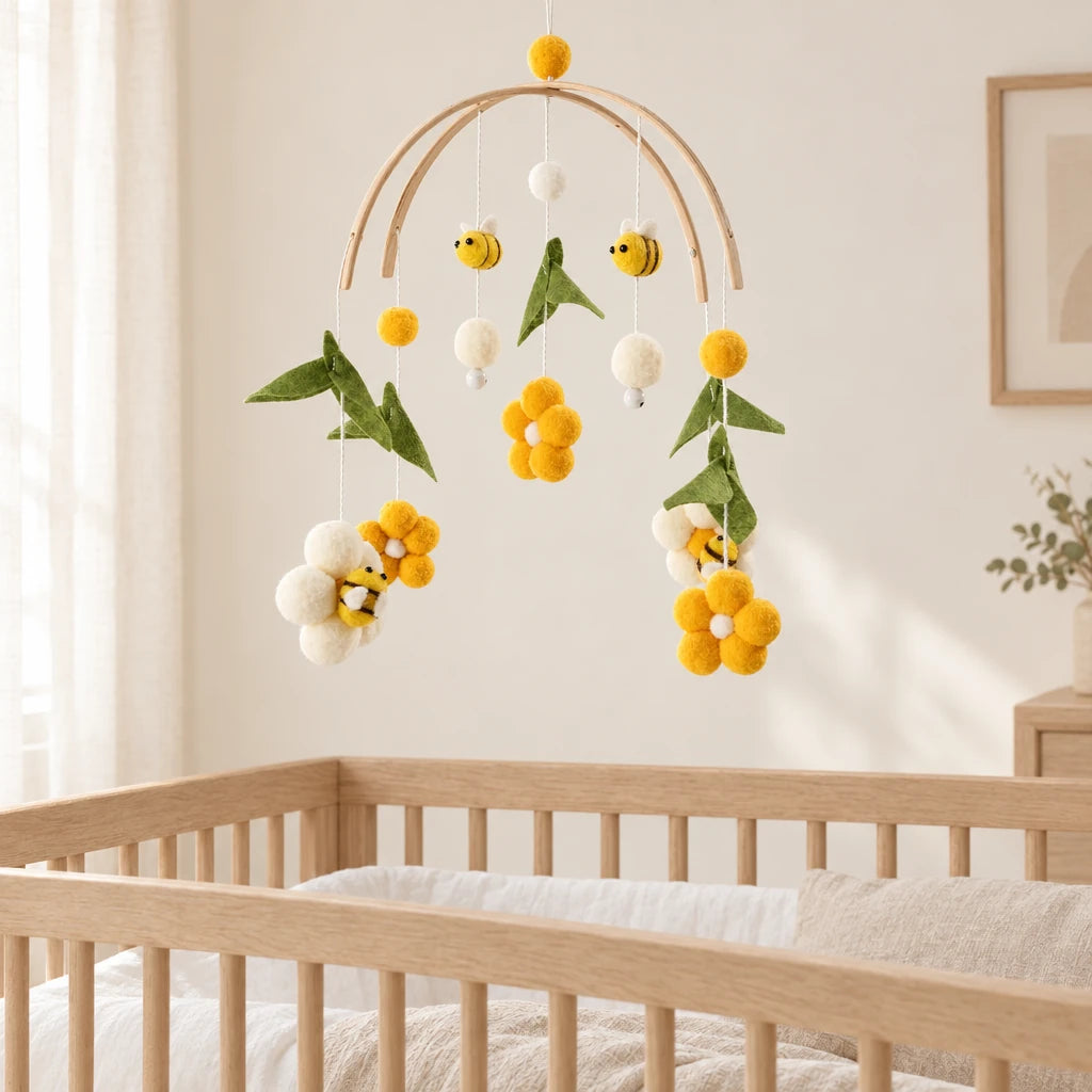 Mobile Bébé Ruche en bois suspendu au-dessus d’un lit bébé en bois clair, dans une chambre douce