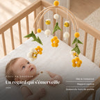 Bébé allongé dans son lit qui regarde le mobile bébé Ruche en bois au-dessus de lui. Un regard qui s’émerveille : dès la naissance, regard captivé, suspendu hors de portée