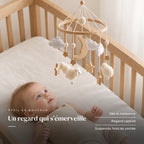 Bébé allongé dans son lit qui regarde le mobile en bois Moutons blancs au-dessus de lui. Un regard qui s’émerveille : dès la naissance, regard captivé, suspendu hors de portée