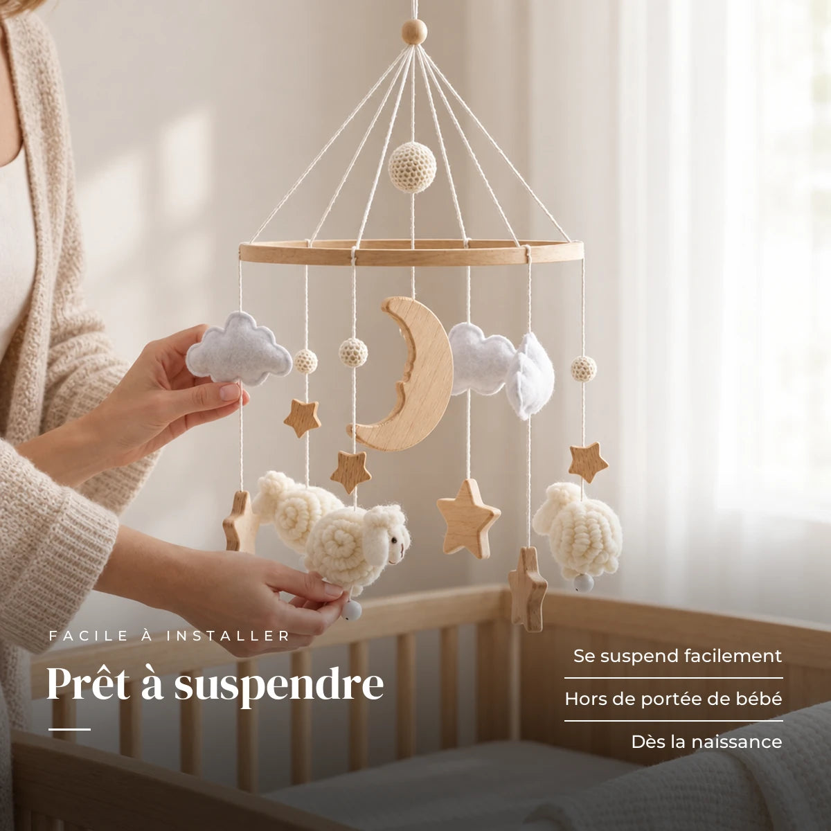 Un parent ajuste une suspension du mobile en bois Moutons blancs au-dessus du lit. Prêt à suspendre : se suspend facilement, hors de portée de bébé, dès la naissance