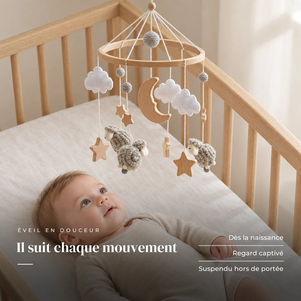 Bébé allongé dans son lit qui regarde le mobile en bois Moutons gris au-dessus de lui. Il suit chaque mouvement : dès la naissance, regard captivé, suspendu hors de portée