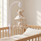 Mobile Musical Nounours avec Bras suspendu au-dessus d’un lit bébé en bois clair, dans une chambre douce