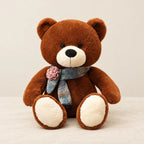 Ours en peluche géant brun avec son écharpe marron foncé sur fond crème, en studio