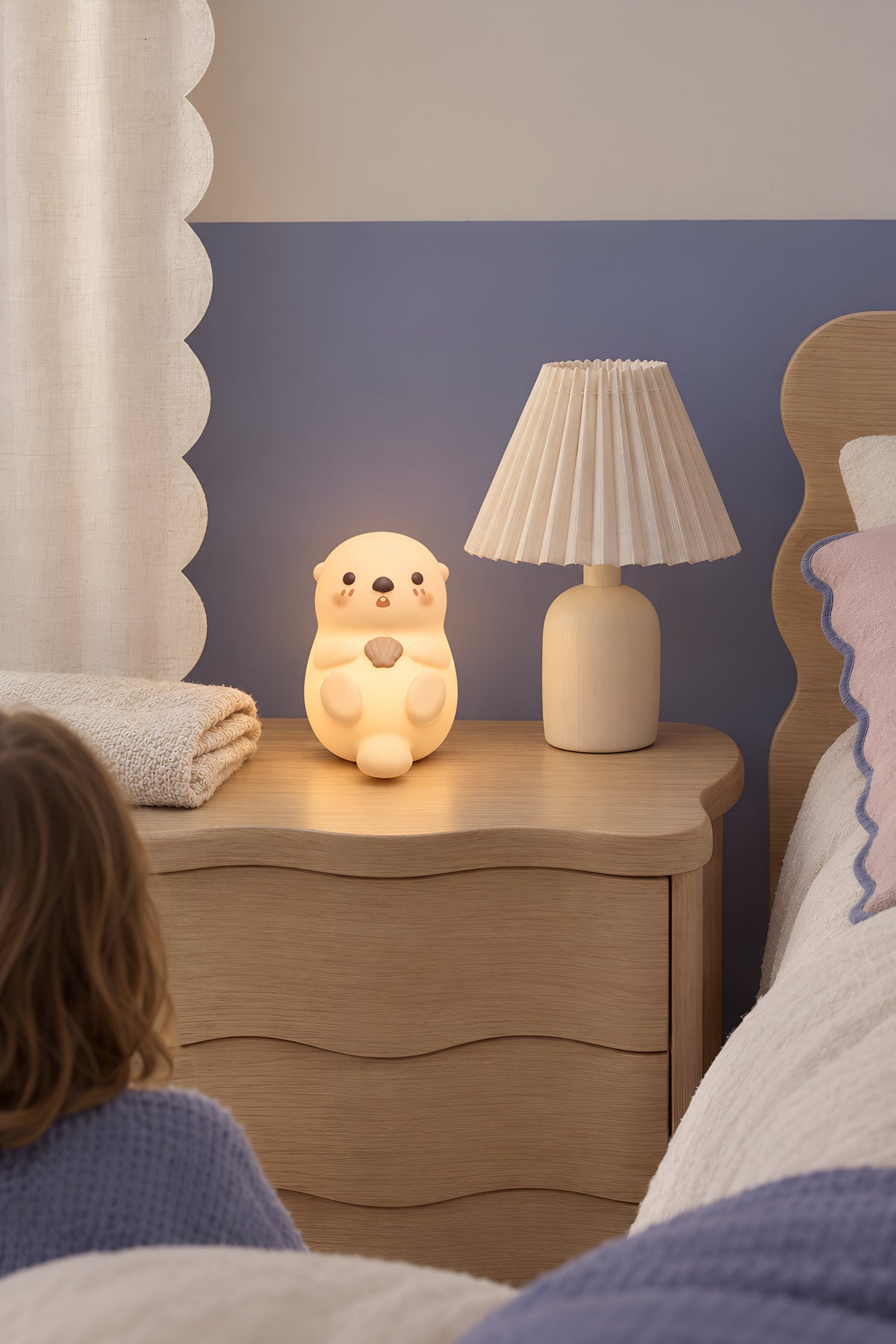 Veilleuse loutre allumée sur une table de chevet