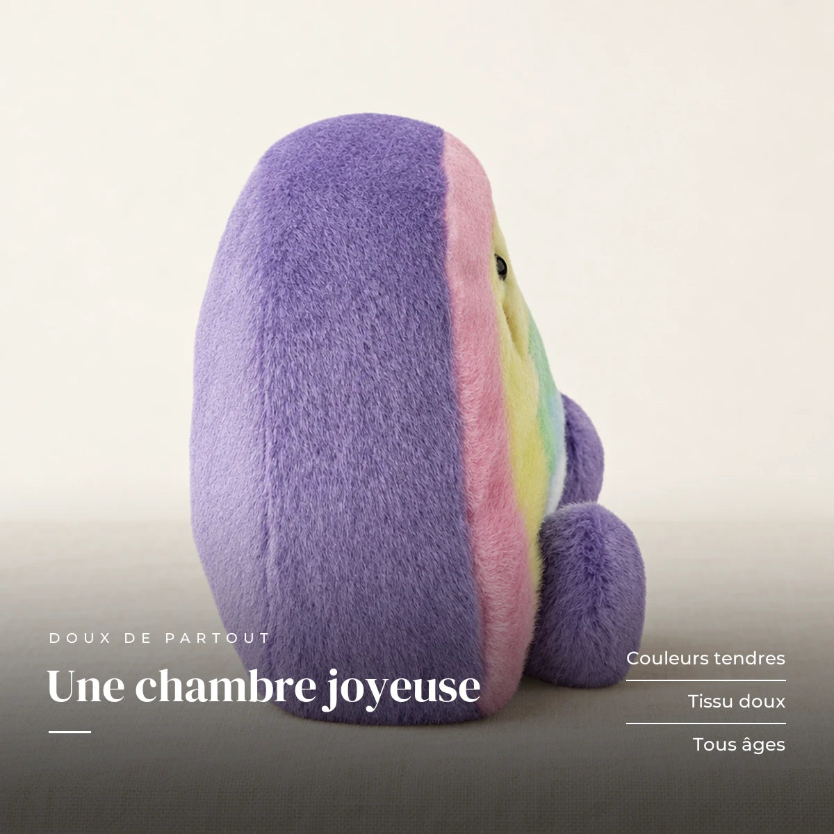 Peluche arc-en-ciel mignon multicolore sur fond crème, en studio. Une chambre joyeuse : couleurs tendres, tissu doux, tous âges
