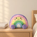 Peluche arc-en-ciel mignon multicolore posée sur une table de chevet en bois clair