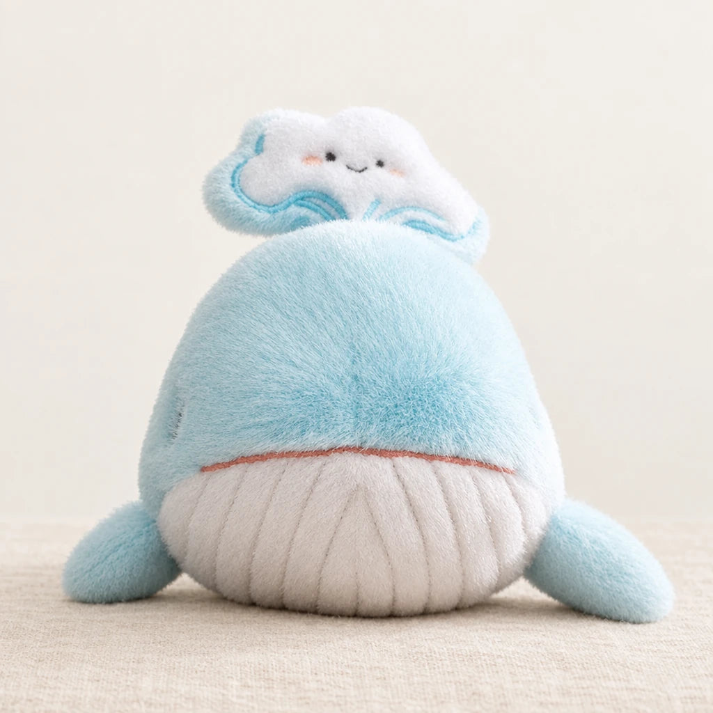 Peluche baleine bleue adorable toute douce sur fond crème, en studio