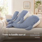 Peluche baleine magique géante installée sur un canapé en lin. Toute la famille narval : yeux brodés, coutures renforcées, moelleuse