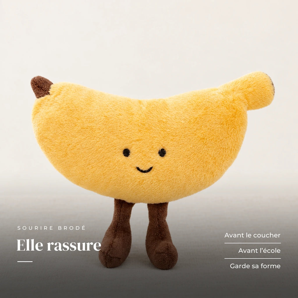 Peluche fruit kawaii banane joviale sur fond crème, en studio. Elle rassure : avant le coucher, avant l’école, garde sa forme