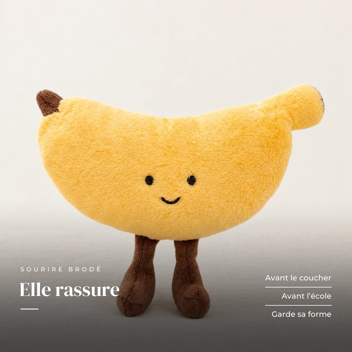 Peluche fruit kawaii banane joviale sur fond crème, en studio. Elle rassure : avant le coucher, avant l’école, garde sa forme