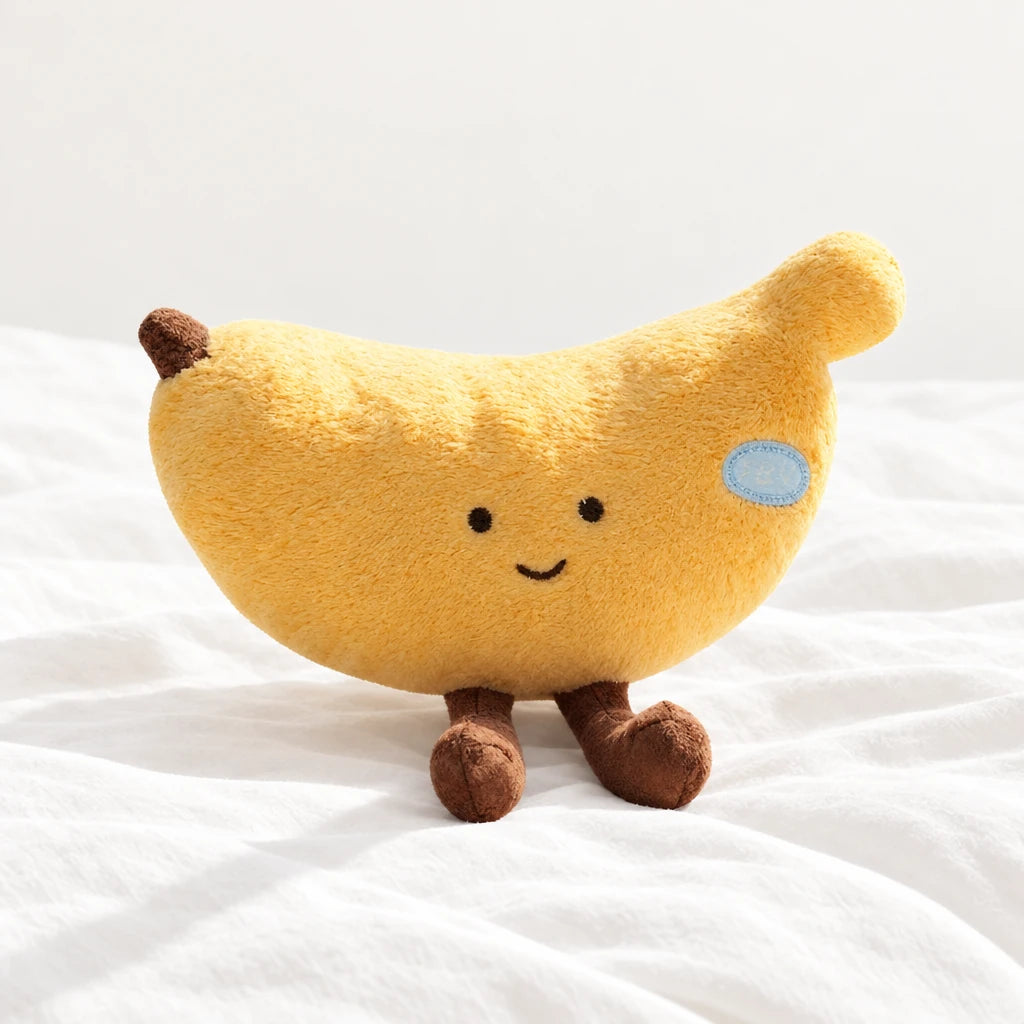 Peluche fruit kawaii banane joviale posée sur un lit blanc, en pleine lumière