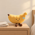 Peluche fruit kawaii banane joviale posée sur une table de chevet en bois clair