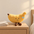 Peluche fruit kawaii banane joviale posée sur une table de chevet en bois clair