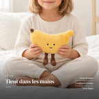 Peluche fruit kawaii banane joviale tenue par un enfant pour montrer sa taille réelle. Tient dans les mains : yeux brodés, coutures solides, tous âges