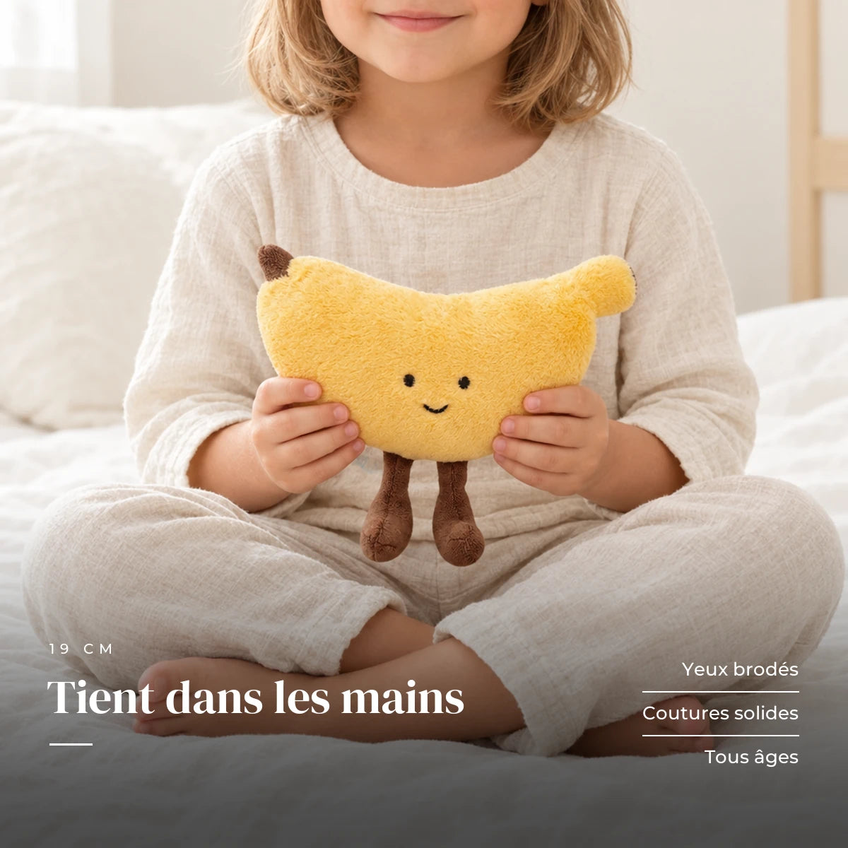Peluche fruit kawaii banane joviale tenue par un enfant pour montrer sa taille réelle. Tient dans les mains : yeux brodés, coutures solides, tous âges