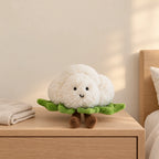 Peluche légume kawaii chou-fleur craquant posée sur une table de chevet en bois clair
